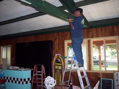 Charlie Johnston on ladder hanging decorations